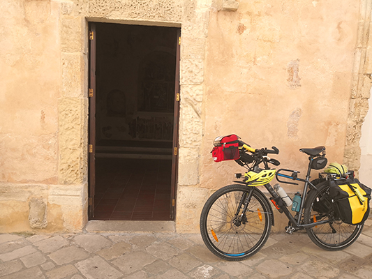 Porta aperta agli affreschi e la bicicletta